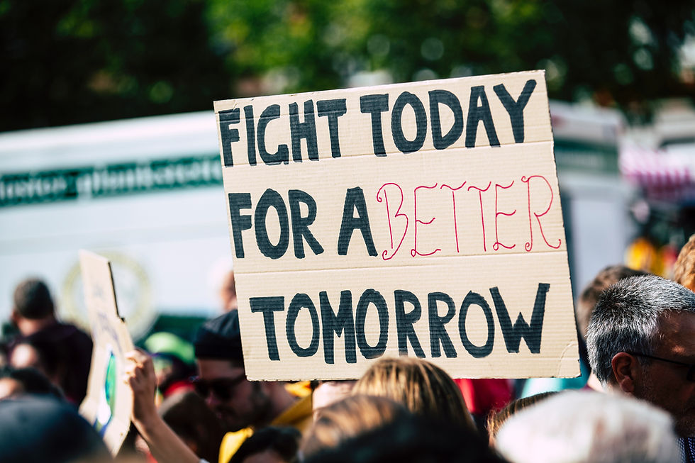 image of a poster being held at a rally that says "Fight today for a better tomorrow"